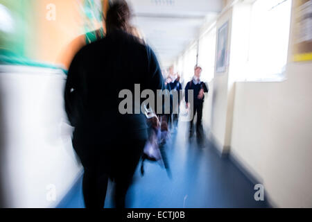 Istruzione secondaria Wales UK - immagine sfocata dei loro figli a scuola gli alunni correndo a piedi lungo un corridoio in tra lezioni Foto Stock