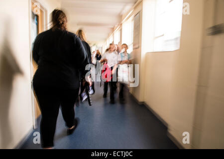 Istruzione secondaria Wales UK - immagine sfocata dei loro figli a scuola gli alunni correndo a piedi lungo un corridoio in tra lezioni Foto Stock