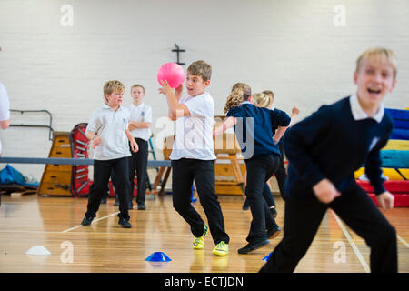 Scuola secondaria educazione fisica Wales UK: Anno 9 bambini che giocano una partita di dodgeball nella scuola palestra a pranzo Foto Stock