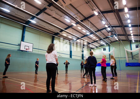 Scuola secondaria educazione fisica Wales UK: ragazze adolescenti a giocare una palla in gioco la palestra Foto Stock