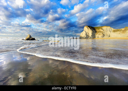 Spiaggia di Sopelana con schiuma di onde e riflessi. Paese basco Foto Stock