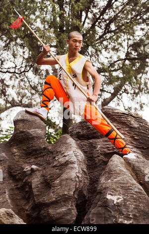 Licenza disponibile su MaximImages.com - studenti giovani Shaolin Kung fu con una lancia in piedi sulle rocce alla cerimonia di apertura di Zhengzhou Internationa Foto Stock