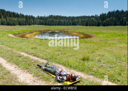 Maschio escursionista caucasica nel suo 40s assume un pisolino nella Kaibab Plateau area sulla Arizona Trail vicino a un serbatoio di acqua, AZ, Stati Uniti Foto Stock