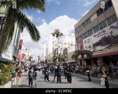 Il hatagashira ( banner / bandiera ) sfilano davanti alla più grande del mondo di tiro della fune, Kokusai Street, citta' di Naha, a Okinawa, Giappone Foto Stock