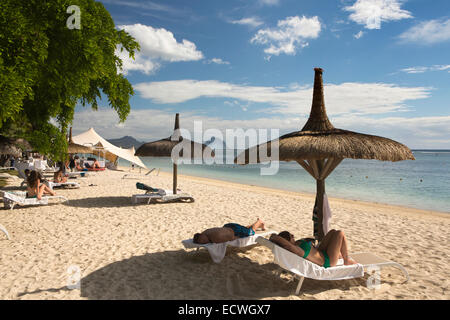 Maurizio, Flic en Flac, spiaggia pubblica, visitatori e prendere il sole sulle sedie a sdraio all'ombra del parasole Foto Stock