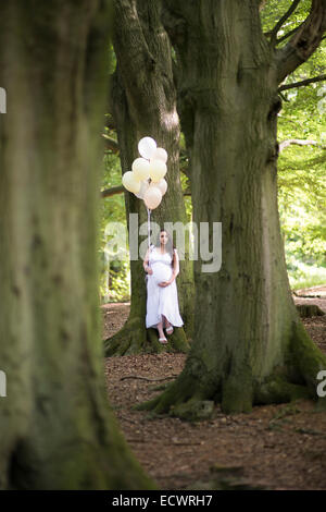 Le donne incinte nei boschi tenendo palloncini. Credito: lee ramsden / alamy Foto Stock