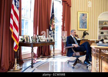 Il Presidente Usa Barack Obama parla al telefono con il prigioniero liberato Alan Gross dall'Ufficio Ovale della Casa Bianca 17 Dicembre 2014 a Washington, DC. Al lordo è stato rilasciato dopo cinque anni di carcere a Cuba come parte di una trattativa per e-stabilire rapporti diplomatici con Cuba dopo 50 anni. Foto Stock