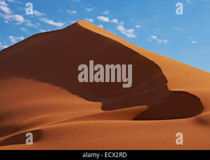 Vista delle dune di sabbia nel deserto con cielo blu e nuvole in background Foto Stock
