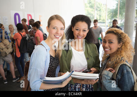 Ritratto di amici universitari in piedi in corridoio con libri Foto Stock