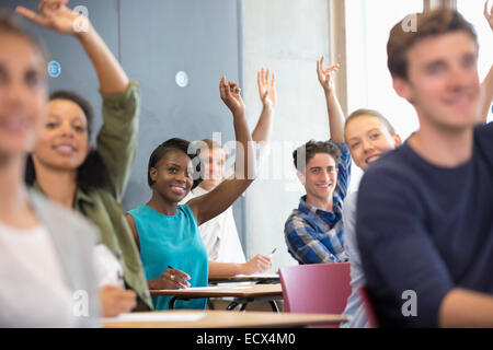 Gli studenti universitari alzando le mani al seminario Foto Stock