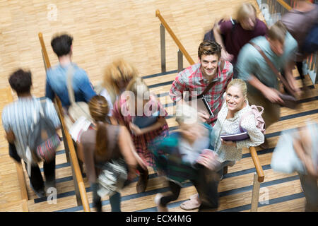 Gli studenti guardando la fotocamera e in piedi sulle scale durante il tempo di interruzione Foto Stock