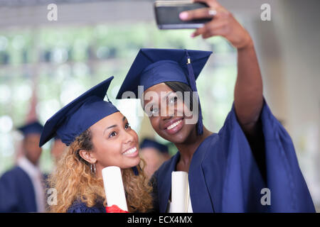 Due sorridenti studentesse tenendo selfie dopo la laurea Foto Stock