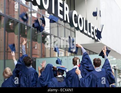Gruppo di studenti di gettare la laurea cappelli al di fuori del college Foto Stock