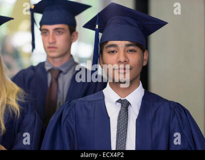 Studente di sesso maschile in abiti di graduazione guardando la fotocamera Foto Stock