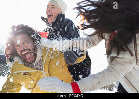 Amici godendo lotta con le palle di neve Foto Stock