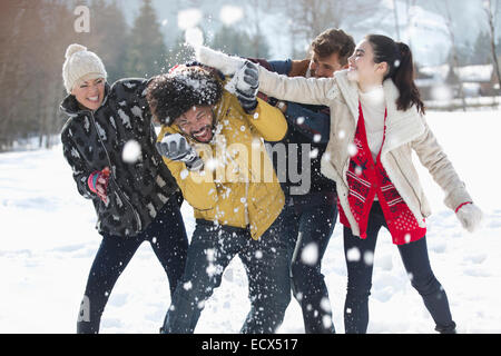 Amici godendo lotta con le palle di neve Foto Stock