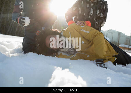 Amici godendo lotta con le palle di neve Foto Stock