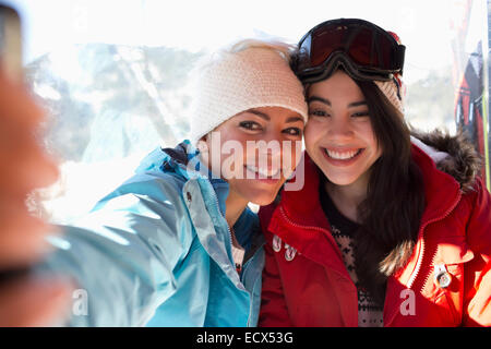 Gli amici di ski lift tenendo selfie Foto Stock