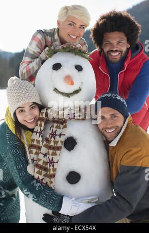 Ritratto di amici con pupazzo di neve Foto Stock