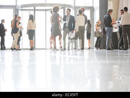 Un gruppo di persone di affari in piedi e parlare in ufficio Foto Stock