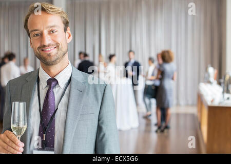 Ritratto di imprenditore sorridente holding flute da champagne Foto Stock