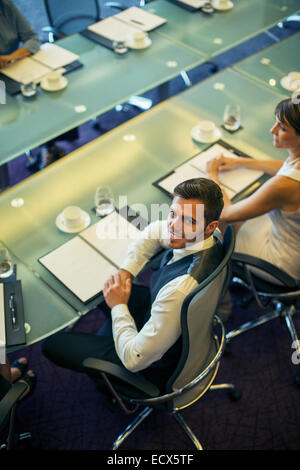 Angolo di Alta Vista del giovane imprenditore seduti ad un tavolo per conferenza Foto Stock