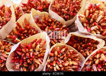 Essiccato a grappoli di pepe in sacchi su un mercato Foto Stock