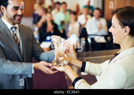 Imprenditore riceve un premio dal sorridente imprenditrice Foto Stock