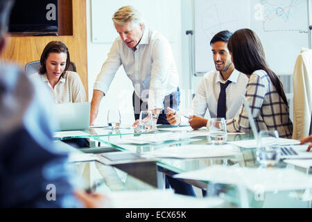 La gente di affari con sale riunioni in sala conferenze, utilizzando laptop e discutere Foto Stock