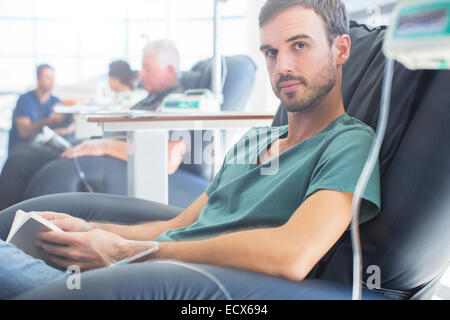 Ritratto di giovane paziente ottenere il trattamento e azienda prenota Foto Stock