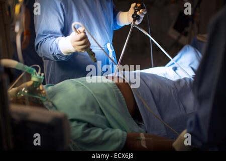 Chirurgo azienda strumenti medicali e di eseguire la chirurgia laparoscopica in sala operatoria Foto Stock