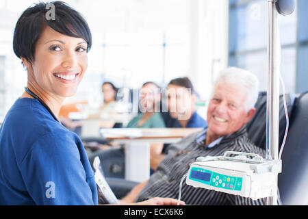 Ritratto di medico sorridente assistere paziente sottoposto a trattamento medico in ambulatorio Foto Stock