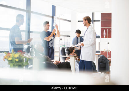 I medici di prendersi cura di pazienti sottoposti a trattamento medico in ambulatorio Foto Stock