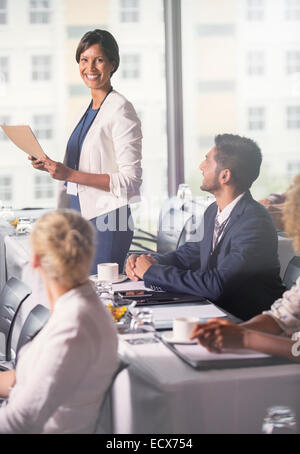 Ritratto di metà adulto imprenditrice dando la presentazione in ufficio Foto Stock