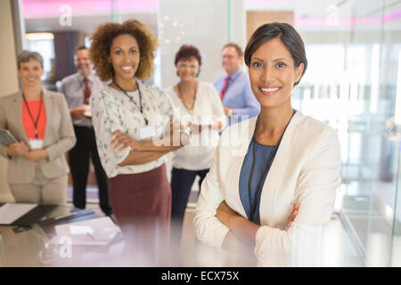Ritratto di fiducioso imprenditrice, con colleghi in background in sala conferenze Foto Stock