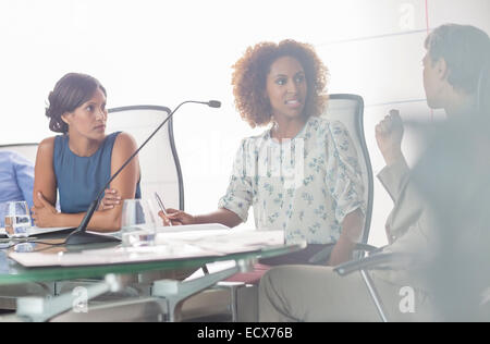 Ritratto di tre donne aventi la discussione a un tavolo per conferenza Foto Stock