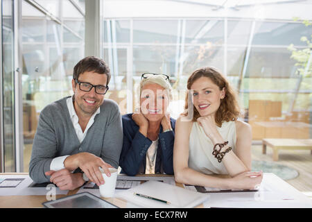 La gente di affari sorridente in ufficio per incontrare Foto Stock