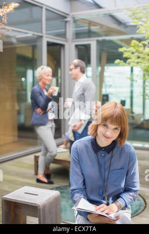 Imprenditrice sorridente in cortile Foto Stock