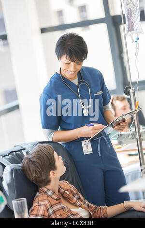 Medico frequentando paziente ricevente in infusione endovenosa in ospedale Foto Stock