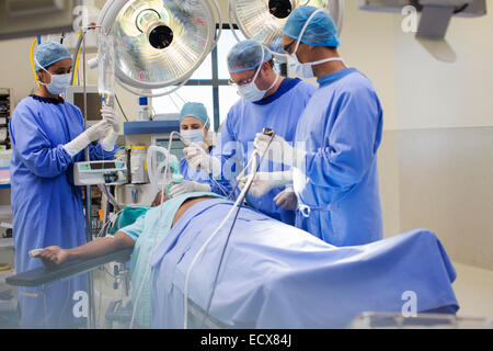 Team di medici di eseguire la chirurgia laparoscopica in sala operatoria Foto Stock