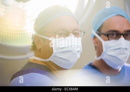 Ritratto di due medici che indossano cappucci chirurgico, maschere e occhiali in sala operatoria Foto Stock