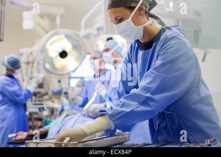 L'infermiera indossando frega la preparazione di strumenti medici in sala operatoria Foto Stock