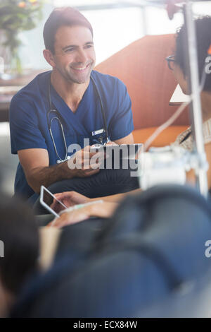 Medico azienda digitale compressa, parlando di paziente sottoposto a trattamento medico in ambulatorio Foto Stock