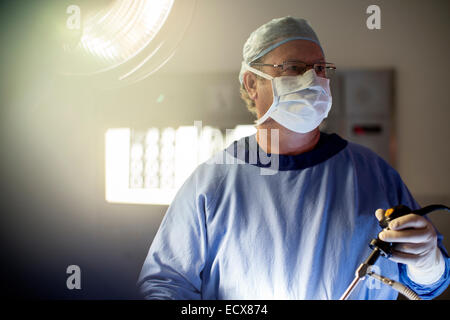 Chirurgo di eseguire la chirurgia laparoscopica in sala operatoria Foto Stock