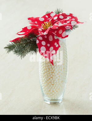 Composizione da Poinsettia piante con rami di abete rosso nel vaso di vetro su sfondo di legno. Primo piano. Foto Stock