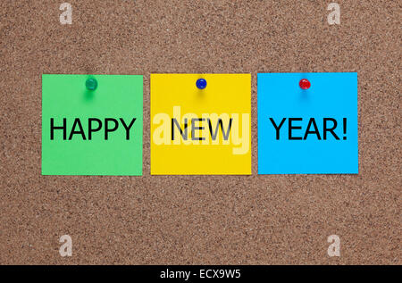 Tre sbozzati post-it sulla bacheca di sughero (bulletin board) con le parole "Happy New Year!". Foto Stock