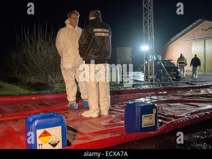 Neuboerger, Germania. Xx Dec, 2014. I dipendenti dell'agenzia veterinaria dell'Emsland distretto amministrativo di stare di fronte alla stie di anatre infettate con l'influenza aviaria in un allevamento di polli in Neuboerger, Germania, 20 dicembre 2014. Il tappeto rosso è parte di un gruppo di disinfezione. In stock della fattoria, l'influenza aviaria da virus H5N8 è stata rilevata. Tutti gli animali saranno uccisi dai gas di biossido di carbonio. Foto: Lars Klemmer/dpa/Alamy Live News Foto Stock