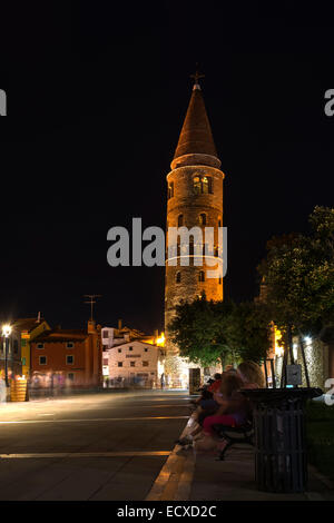 Caorle, Italia Giugno 2014 - notte tempo vista sul Duomo romanico il campanile pendente con visitatori durante le vacanze estive Giugno Foto Stock