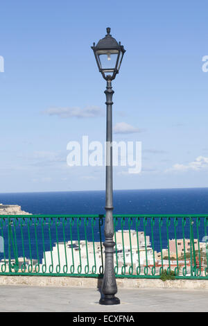 Via lampada su un marciapiede che si affacciano sull'oceano in Malta Foto Stock