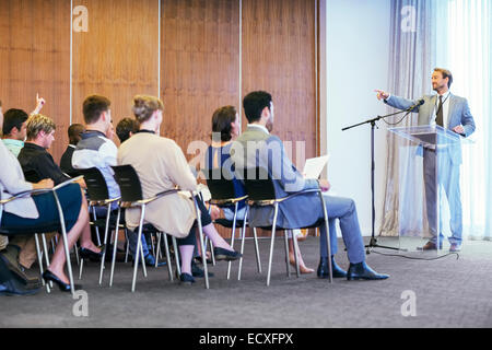 Ritratto di imprenditore in piedi al leggio trasparente parla prima udienza in sala conferenze Foto Stock